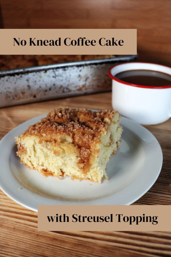 A slice of streusel topped coffee cake sits on white plate with a coffee cup behind it. Text overlay reads: No Knead Coffee Cake with Streusel Topping. 